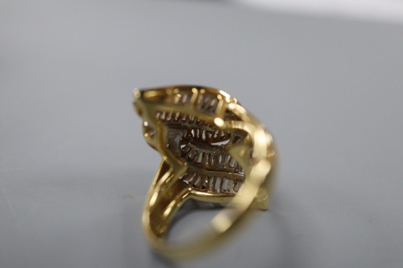 An 18k and trapeze cut diamond cluster set modernist dress ring, size L, gross 8.4 grams.